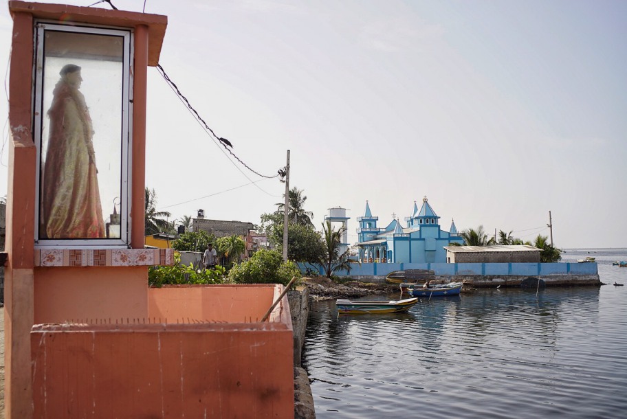 From a glass cabinet, a statue of the Christian saint guards the fishing village in Jaffna, the Tamil part of Sri Lanka.