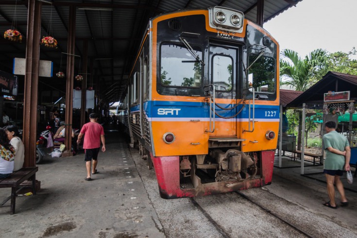 Zwalniający pociąg zatrzymuje się kilkanaście metrów dalej na stacji Maeklong.